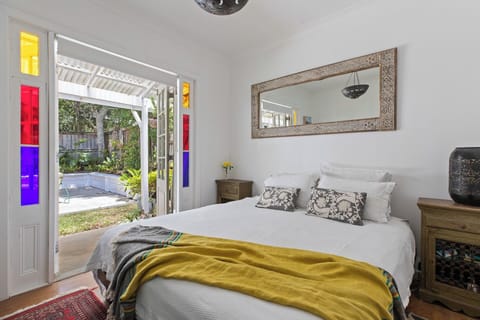 Bedroom with queen bed - french doors open onto courtyard. Room has a Smart TV.
