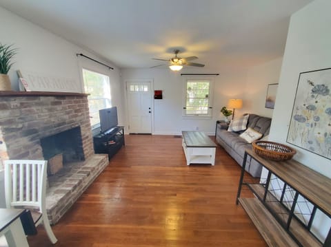 Spacious living room with a cozy fireplace and hardwood floors.