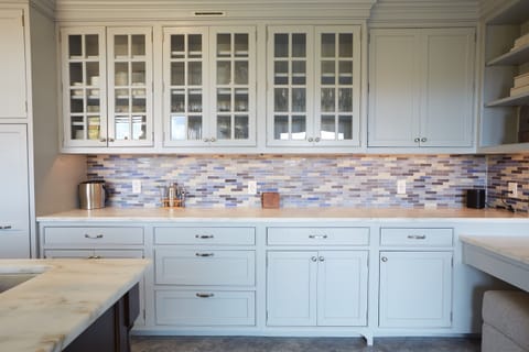 Beautiful details like the custom blue mosaic tile backsplash make this kitchen a joy to cook and entertain in.