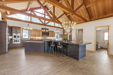 Adjacent to the recreation room, the expansive kitchen boasts a striking black granite island breakfast bar that comfortably seats 4 up to 8, perfect for casual dining or entertaining.