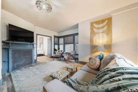 - Relax in a bright living room featuring soft tones, stylish wall art, and a large smart TV for cozy movie nights   - Natural light fills the space through wide windows, creating a welcoming atmosphere   - Thoughtfully designed décor blends comfort and mo