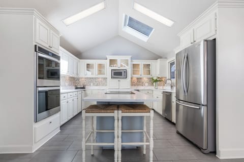 Kitchen with long Island with Bar chairs for relaxing while assisting the Chef