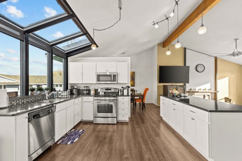 Enjoy cooking in the brightly lit  fully stocked kitchen with its open living space with the living room.