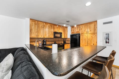 Full kitchen with breakfast bar seating up to 3.