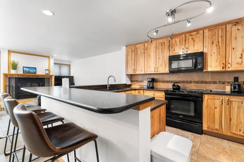Full kitchen with breakfast bar seating up to 3.