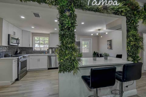 Enjoy a meal or chat with friends at the kitchen bar counter—an ideal spot for casual dining! #KitchenStyle #BarCounter #TampaRetreat