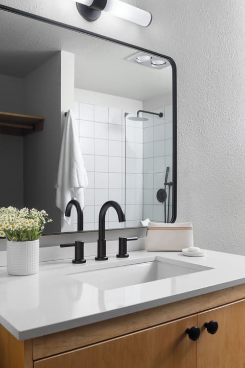 Refresh easily with bright vanity, matte-black fixtures, roomy mirror.