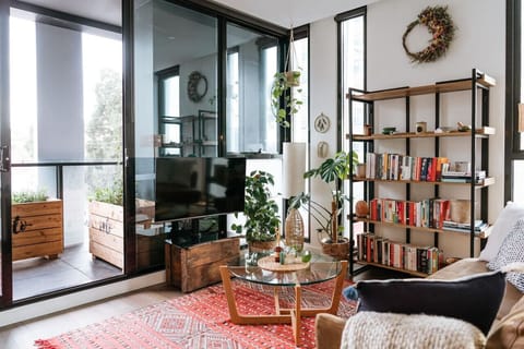 A wall of books, natural light, and oak floors create a sanctuary that welcomes you to unwind and stay just a little longer.