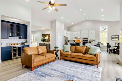 Open-concept living area featuring a cozy seating space, modern kitchen, and stylish wet bar, perfect for entertaining and relaxing.