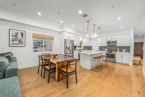 View of open concept dining table and kitchen, perfect for spending time with family and friends.