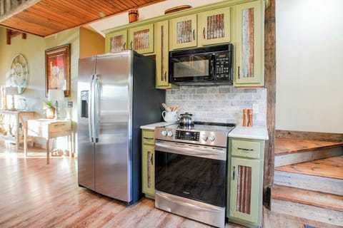 This cabin’s kitchen boasts unique reclaimed wood cabinets, stylish tile backsplash, and modern amenities to make meal prep easy and enjoyable for groups of all sizes.