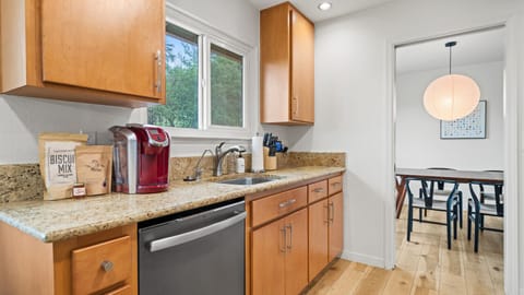 Kitchen equipped with electric stovetop, oven and small coffee bar.