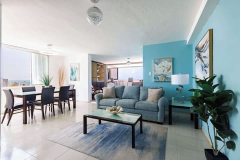 This open-concept living space blends ocean-inspired colors with elegant modern design. Featuring a cozy sofa, chic dining area, and stunning sea views — perfect for relaxing or entertaining during your coastal getaway.