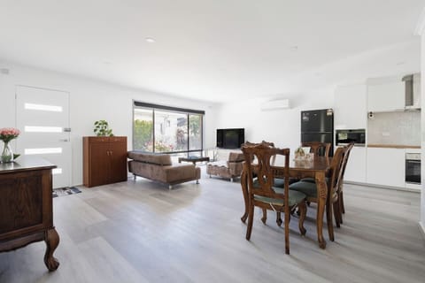 Spacious dining area adjacent to a fully equipped kitchen, perfect for shared meals and entertaining.
