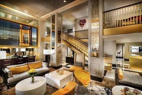 Unwind in a glamorous double-height lounge with skyline art.