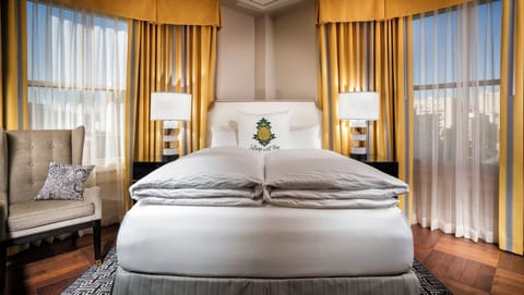 Unwind in a sunlit king bed with crisp linens.