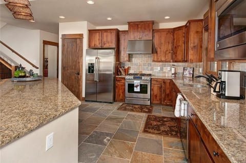 Full kitchen featuring stainless steel appliances, and breakfast bar seating 3.