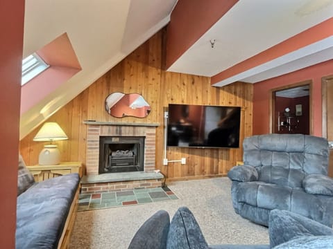 Warm living room with fireplace and TV.