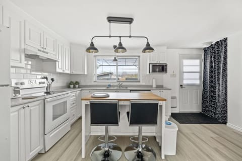 Functional kitchen with island seating, bright open layout, and direct outdoor access for easy dining.