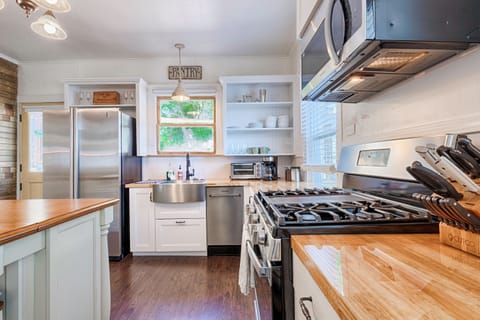 Chef's kitchen with stove, microwave, island, dishwasher and deep sink with view