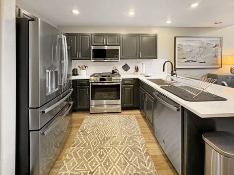 Cook like a chef in this fully-equipped kitchen with gleaming stainless steel appliances. Everything you need - oven, stovetop, full-size refrigerator/freezer, microwave, island sink, and dishwasher for effortless meal prep