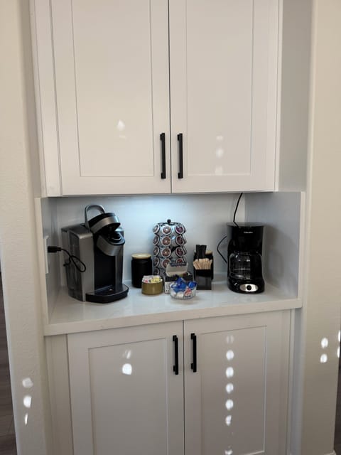 A fully stocked coffee & tea station features a Keurig, drip coffee maker & tea