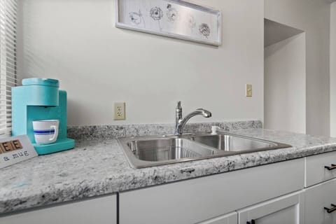 Modern full kitchen featuring a sleek sink with faucet, a stylish coffee maker, and elegant granite countertops—designed for functionality and style, offering a perfect space for cooking, brewing coffee, and enjoying a contemporary kitchen experience