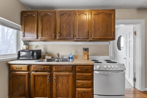 Fully equipped kitchen featuring a gas stove, microwave, and all the cookware and supplies you need to prepare delicious meals.