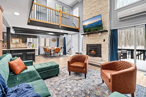 Relaxation at its finest—soft sofas, a crackling fireplace, and a cinematic TV!