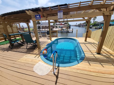 Paradise B heated pool beneath a pergola on the deck with a breathtaking canal view