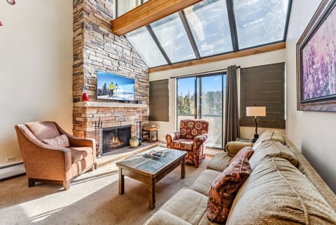 Living Room: Couch with pull-out bed, 2 lounge chairs, 50” Smart TV with cable, wood-burning fireplace, large windows, views of ski slopes