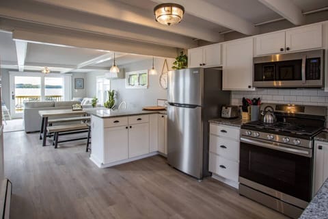 This sleek, modern kitchen seamlessly blends style and functionality. The space is anchored by clean lines and minimalist design, with cabinetry in neutral tones that complement the polished countertops made of granite.