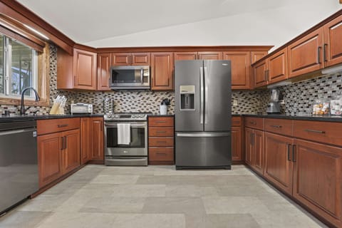 Fully stocked kitchen with granite countertops, coffee station, blender, cookware, toaster oven, and all other necessary cooking items.