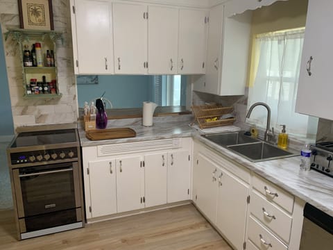 Well stocked kitchen with some dry goods & Non perishables in cabinets for use. 