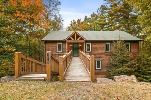 Enter the cabin sanctuary through a charming gateway, where warmth and tranquility welcome you to your haven in the woods.