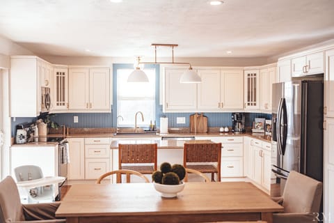 A modern dining space for 6 and kitchen with an island offering 2 counter seats.