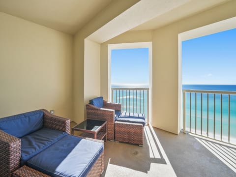 Your private oceanfront balcony awaits with plush seating and breathtaking turquoise views—perfect for morning coffee or sunset cocktails.