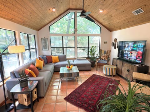 Vaulted living room, door to deck, sofa, coffee table, Smart TV ceiling fan