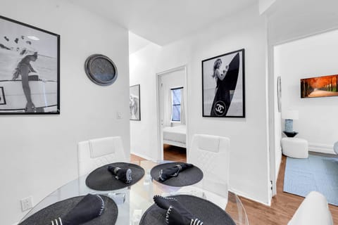 Modern dining area with stylish decor, large windows, and a view into adjacent rooms.
