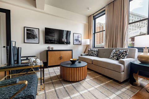 A bright, open living and dining area with large windows that frame stunning downtown views and enhance the modern interior design.
