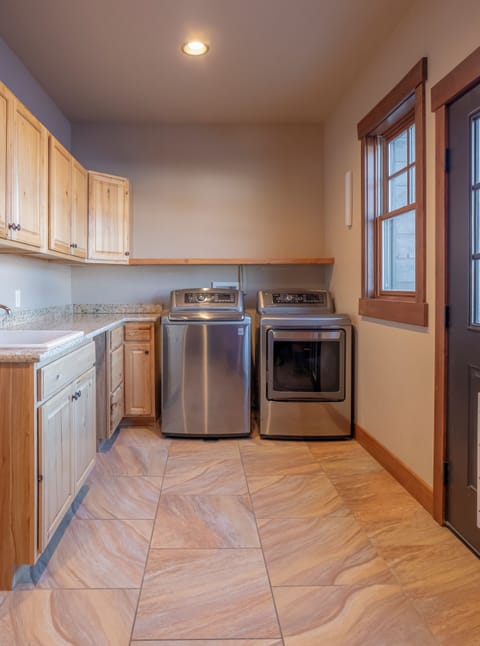 Spa towels are neatly stored in the laundry room cabinets.
