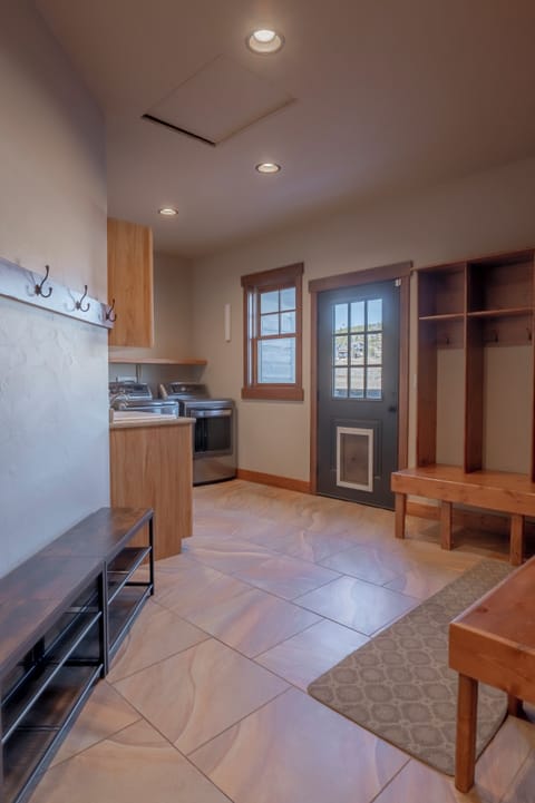 The mudroom features a washer, dryer, sink, and storage for outdoor gear.