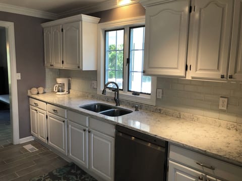 Custom lighting, glass tile backsplash, double stainless steel sinks and Keurig