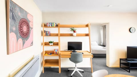 Bright and cozy study nook with natural light, sleek workspace, and warm wooden shelving for the perfect work-from-home setup.