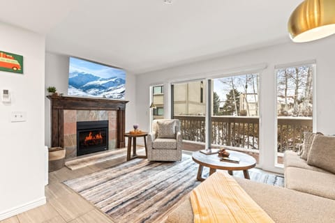    Cozy living room with fireplace, snowy views, and modern comfort.