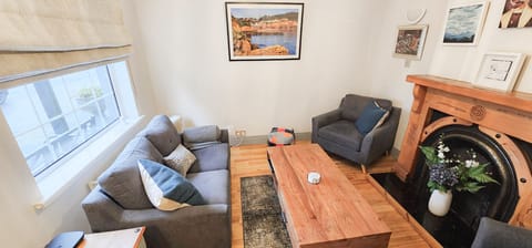 Passage East, Co Waterford. Family holiday home, close to ferry. Living room, modern suite, fireplace, wooden floors. Bright window.