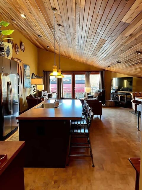 View from the hall into the open concept kitchen/dining/living area. Cedar vaulted ceilings and cork floors throughout.