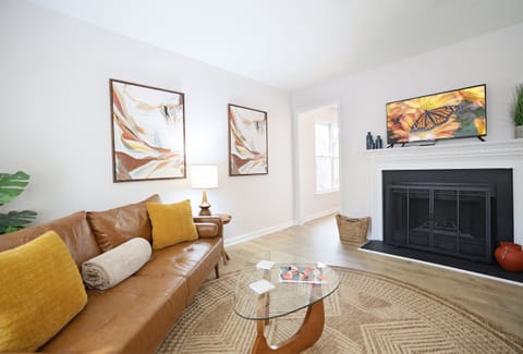 Living Room with leather couch, fireplace and large TV