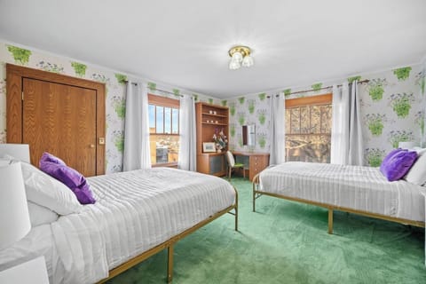 This Monet-inspired bedroom features two new, queen sized beds, floral accents, and gorgeous natural lighting!