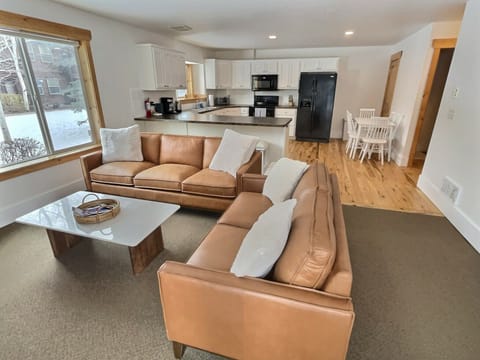 Cozy living room area with fireplace and 65" Start TV, patio area just outside